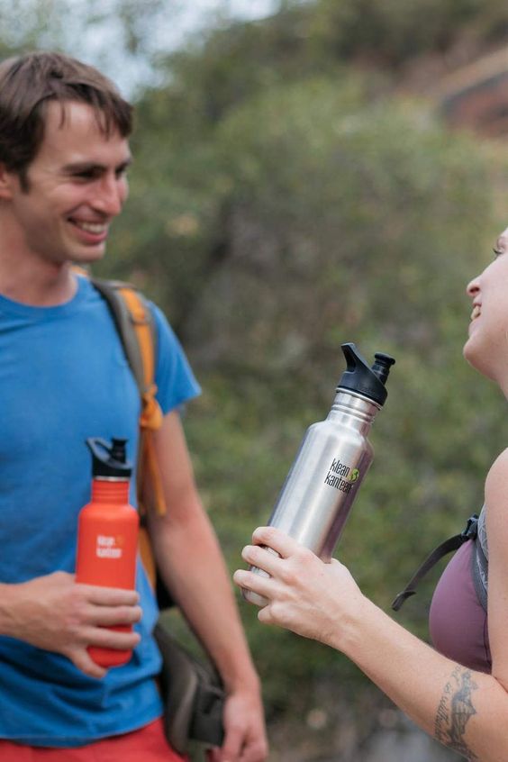 klean kanteen termosky chlap a žena držiaci v ruke klean kanteen termosky na horách